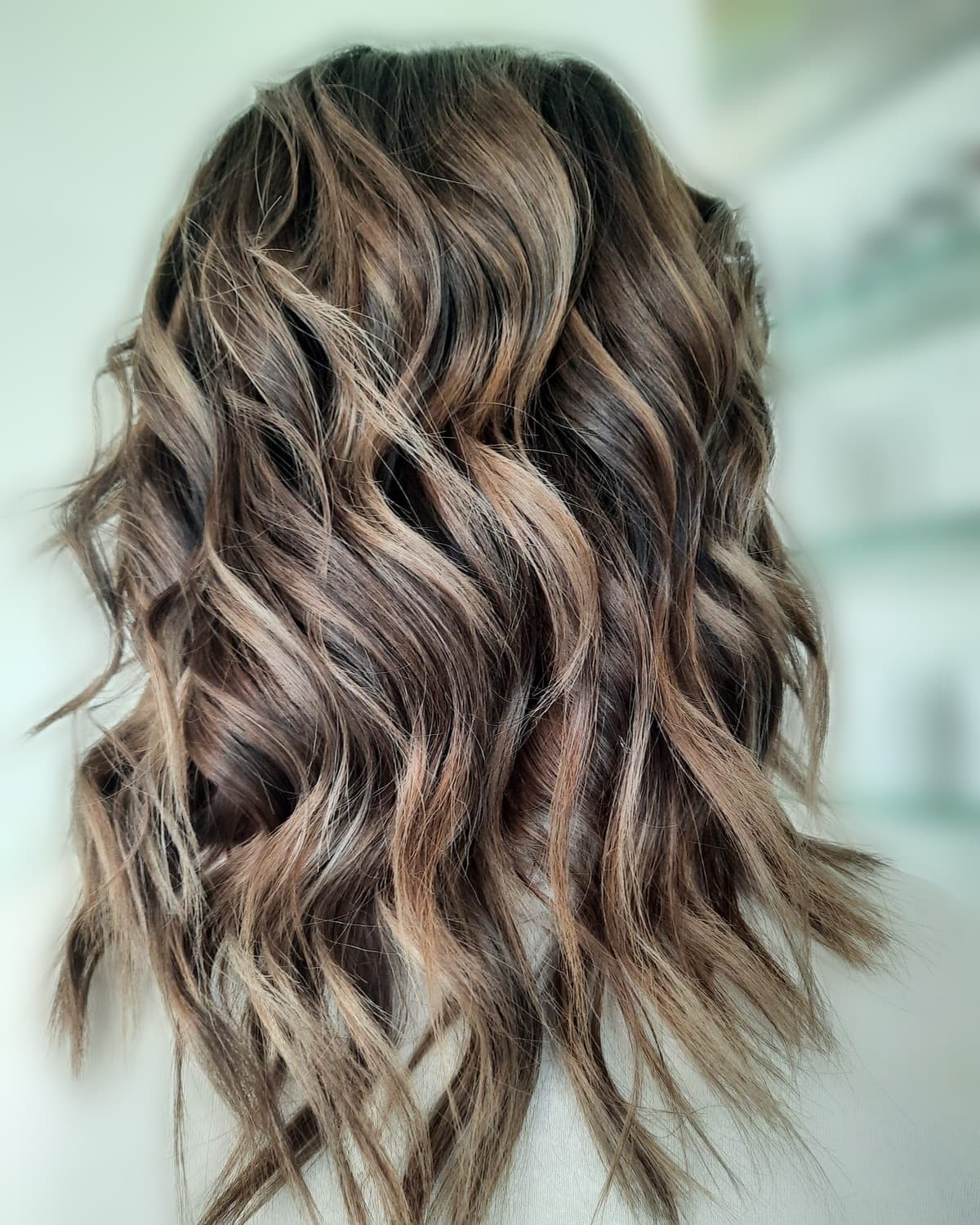 Dunkelbraunes Haar mit Karamell-Balayage und Wellen